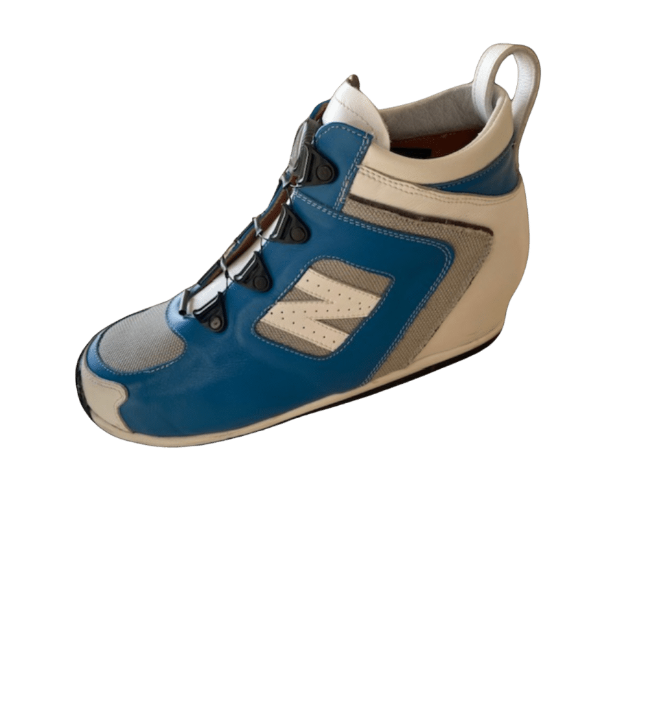 Basket New Balance bleue et beige, logo N, laçage rapide et talon compensé sur fond blanc.